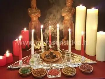 Tavolo rituale con candele chiare e rosse, erbe e resine